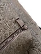 Dior mini backpack close-up of zipper pull and embossed leather texture