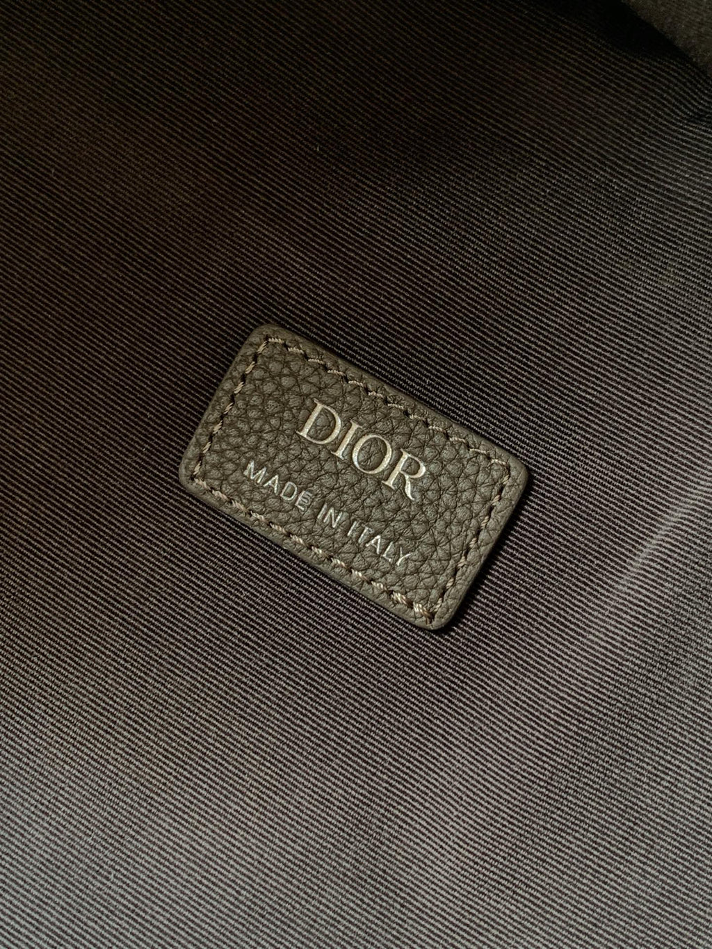 Dior men's backpack interior label reading DIOR MADE IN ITALY