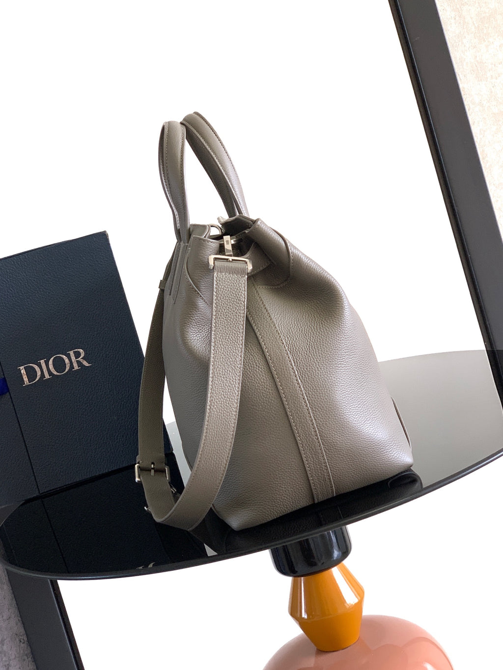 Dior men’s light gray leather tote bag with adjustable shoulder strap and metal buckle