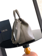 Dior men’s light gray leather tote bag with adjustable shoulder strap and metal buckle