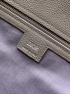 Dior handbag close-up of zip pocket and Dior Made in Italy label, light gray
