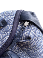 Bag interior view with Dior logo patch on blue textured lining and stitched pocket