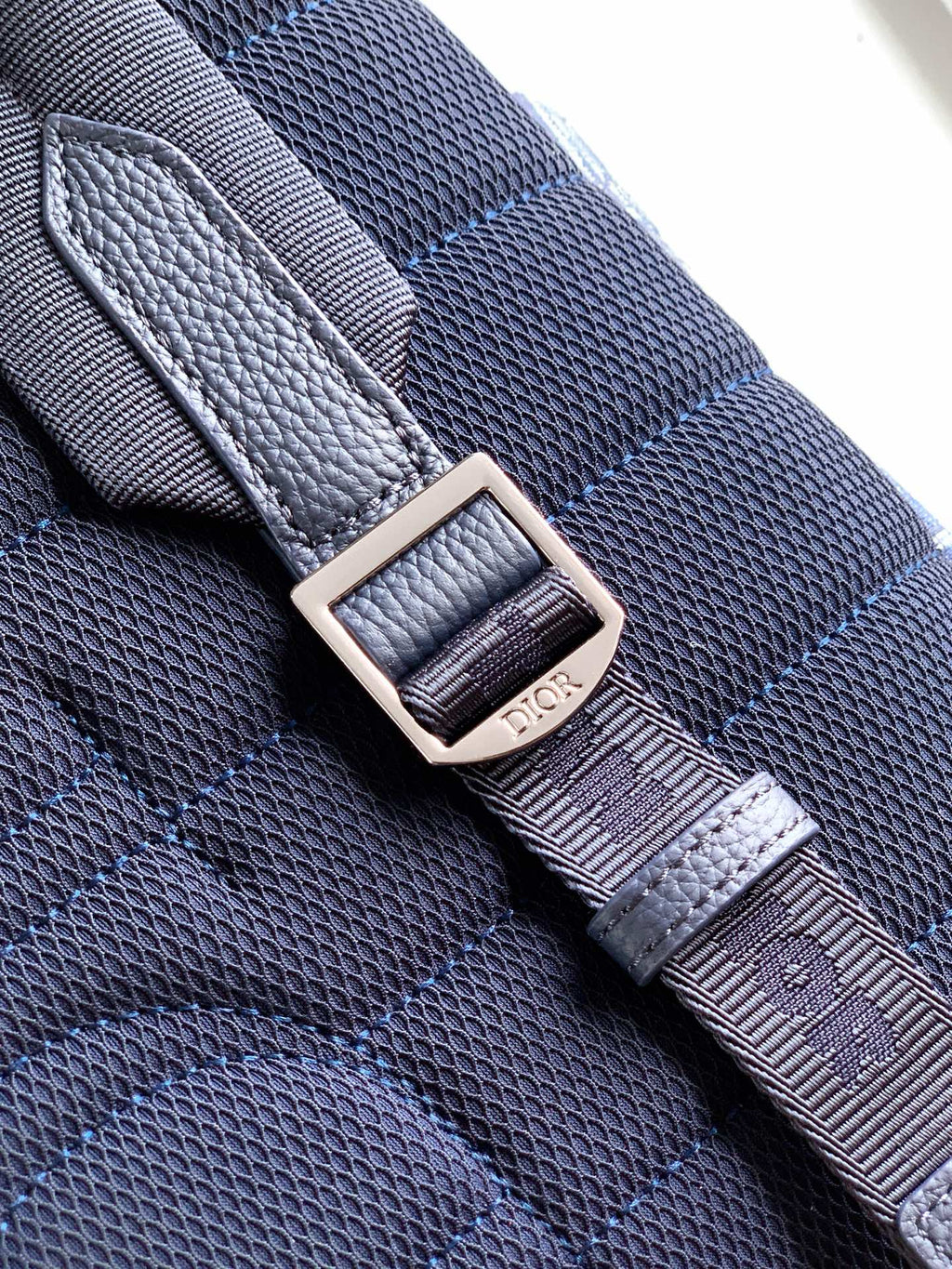 Adjustable bag strap with metal buckle and stitched keeper, blue textured finish