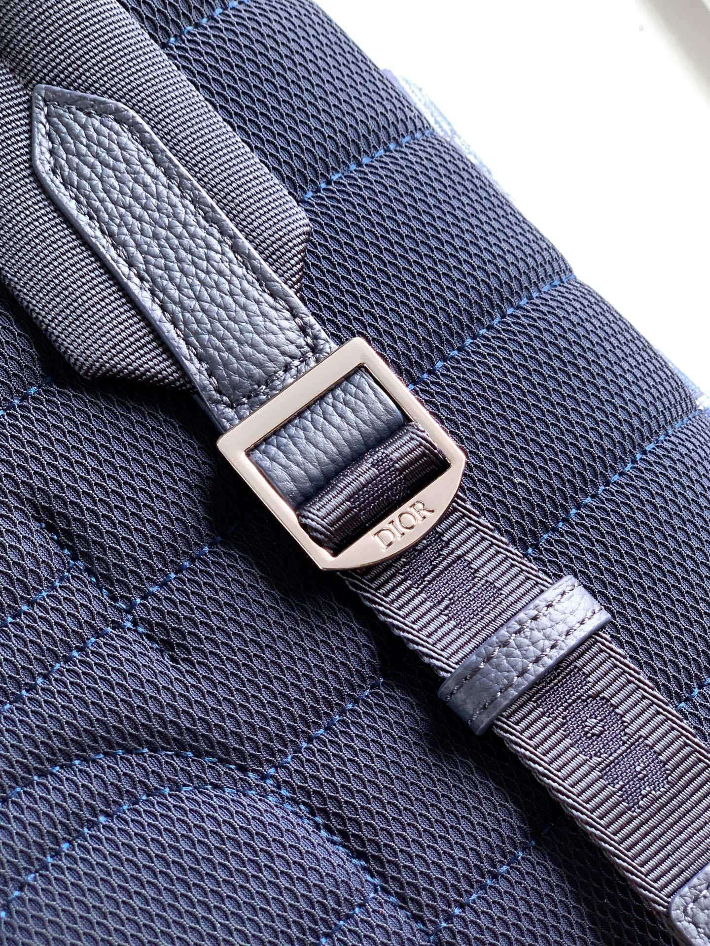 Adjustable bag strap with metal buckle and stitched keeper, blue textured finish