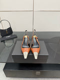 Women’s high-heel pumps with orange patent upper, black heel, silver YSL toe tips