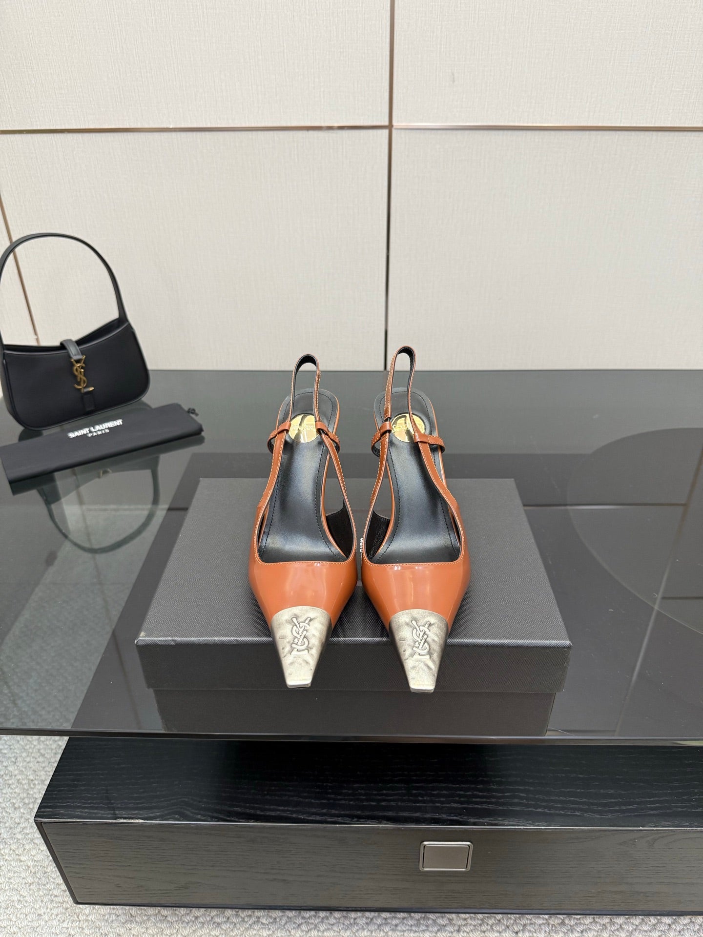 Women’s high-heel pumps with orange patent upper, black heel, silver YSL toe tips