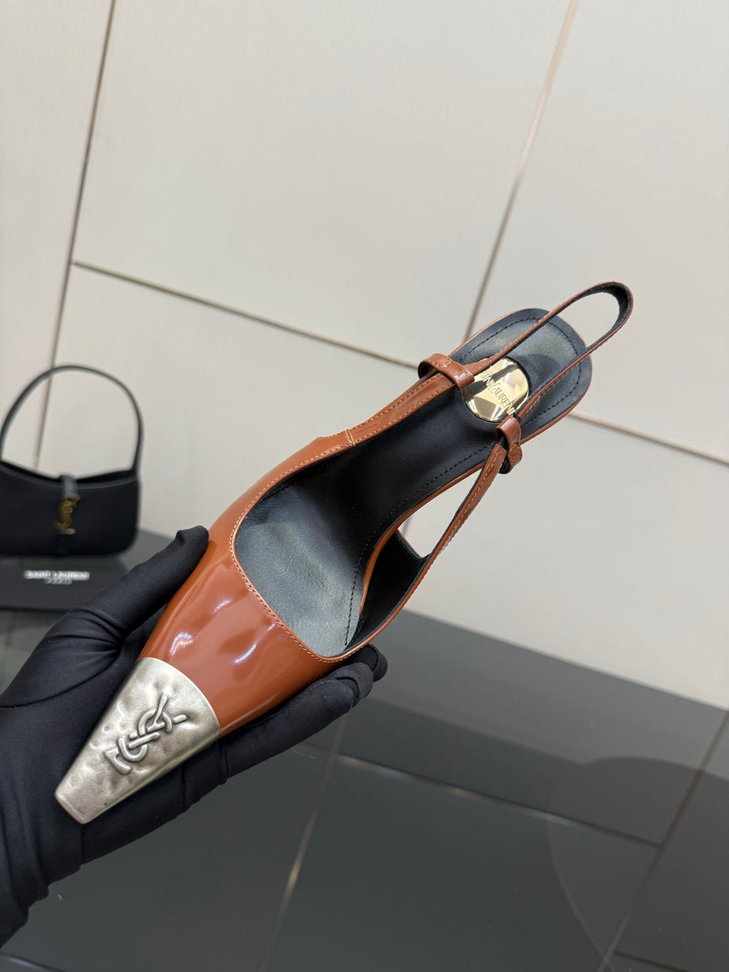 Women’s high-heel slingback pump with orange patent upper, black lining, and silver toe tips