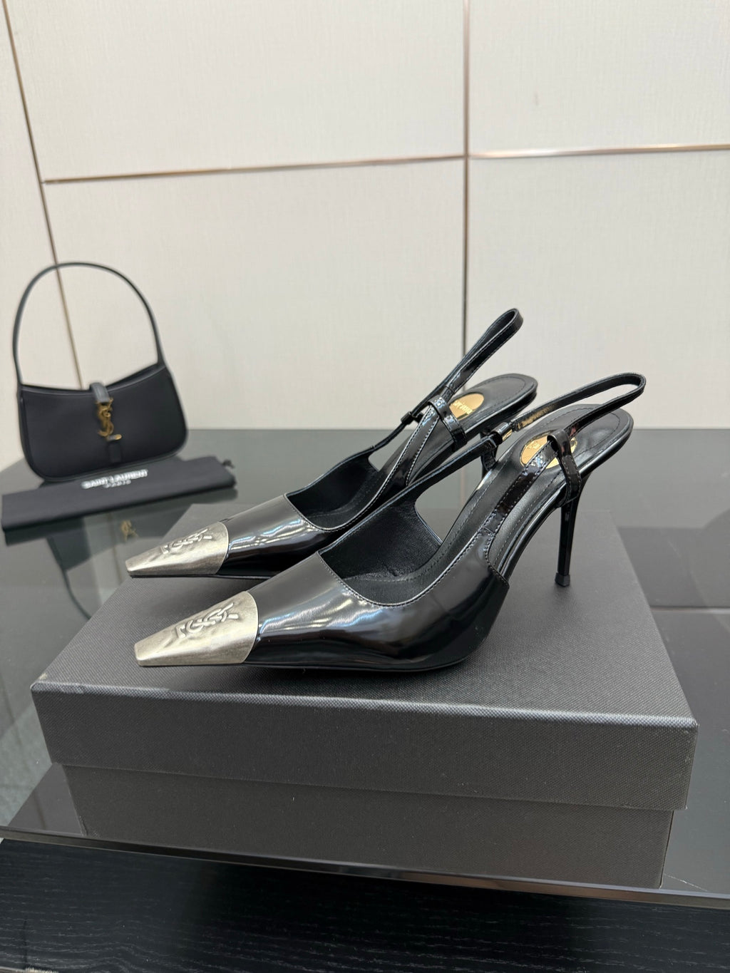 Women's YSL black patent slingback pumps with pointed toes and stiletto heels