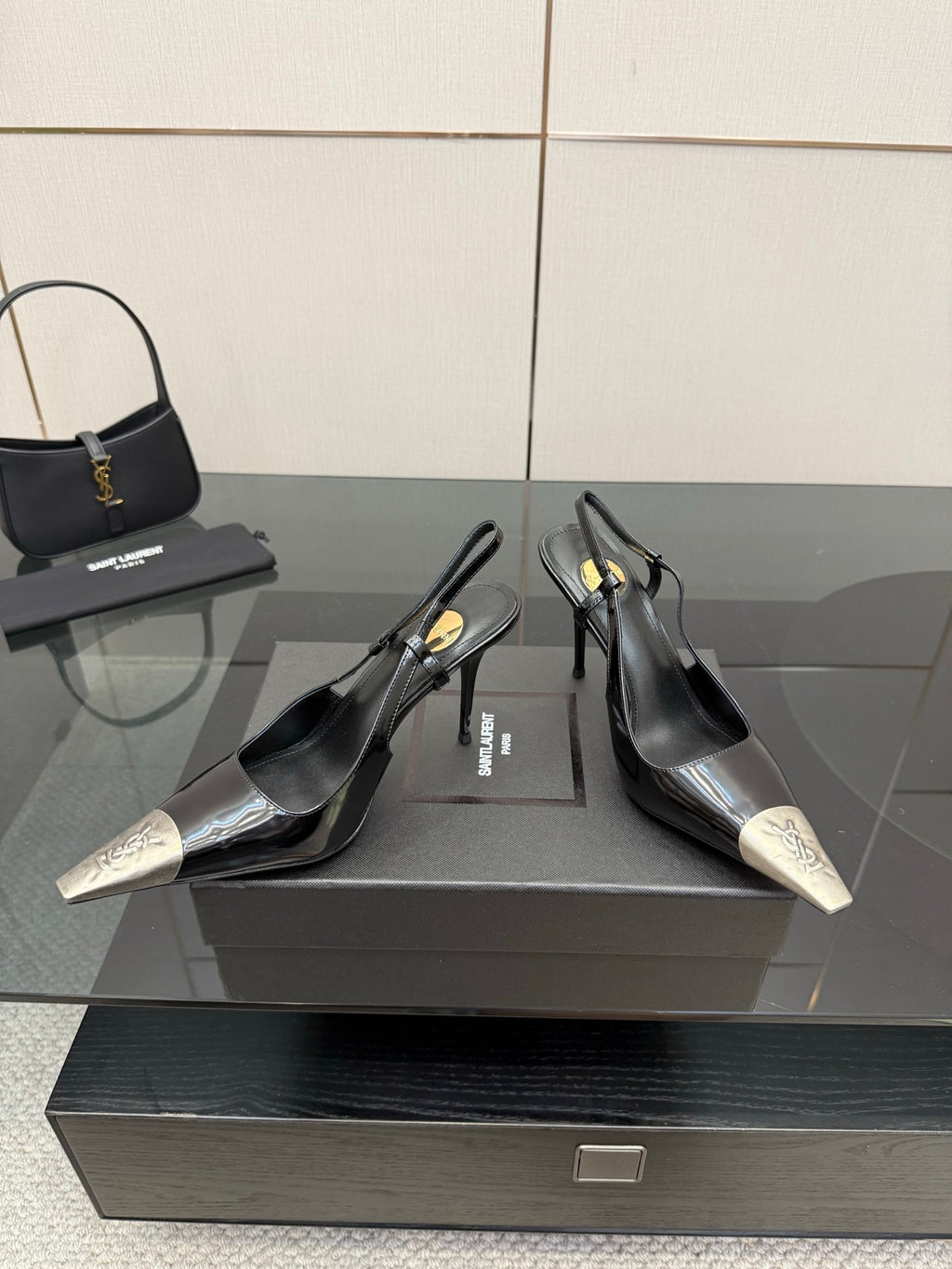 Women's YSL black slingback pumps with metallic silver toe caps and stiletto heels