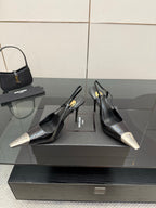Women's YSL black slingback pumps with metallic silver toe caps and stiletto heels