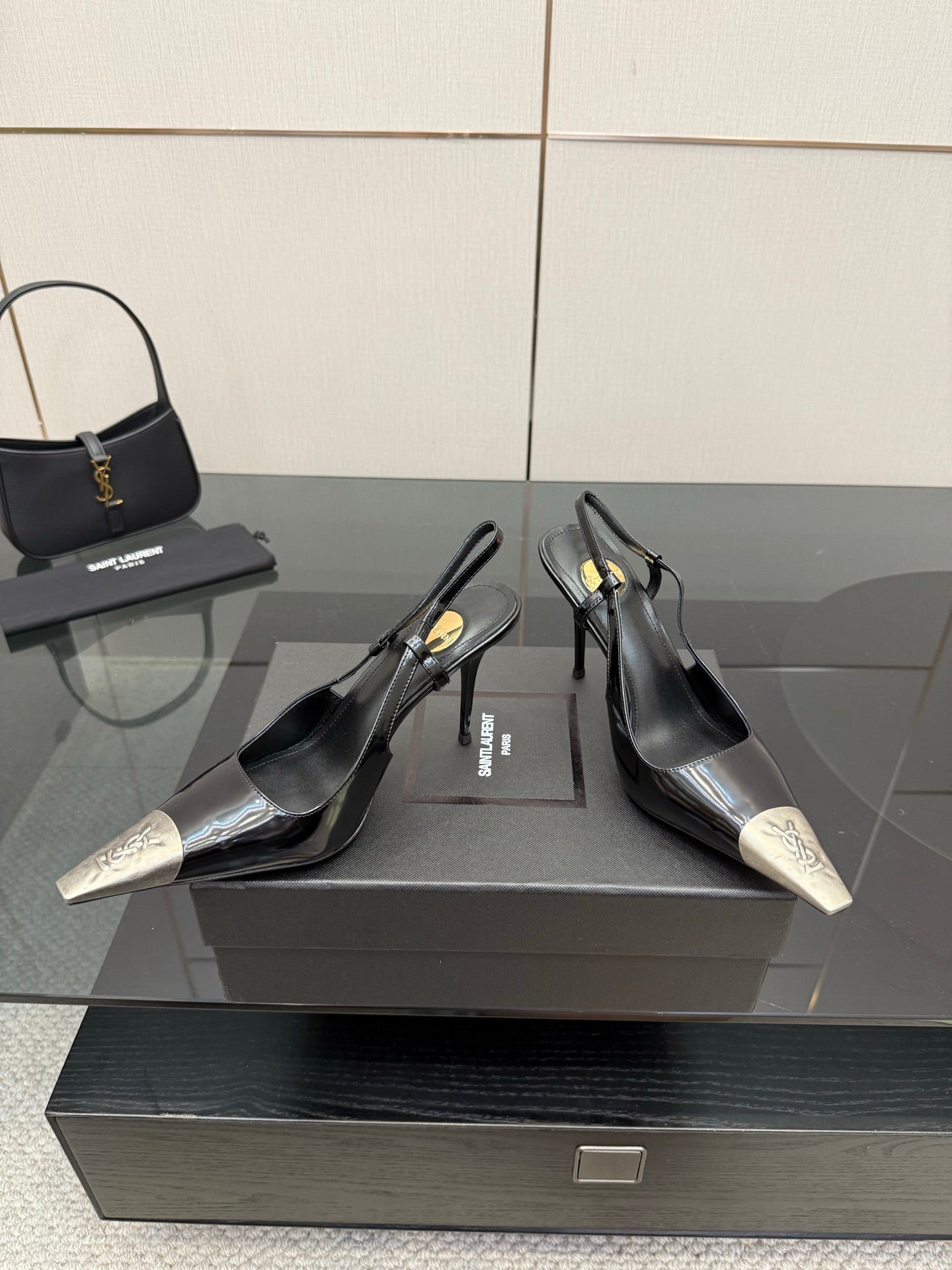 Women's YSL black slingback pumps with metallic silver toe caps and stiletto heels