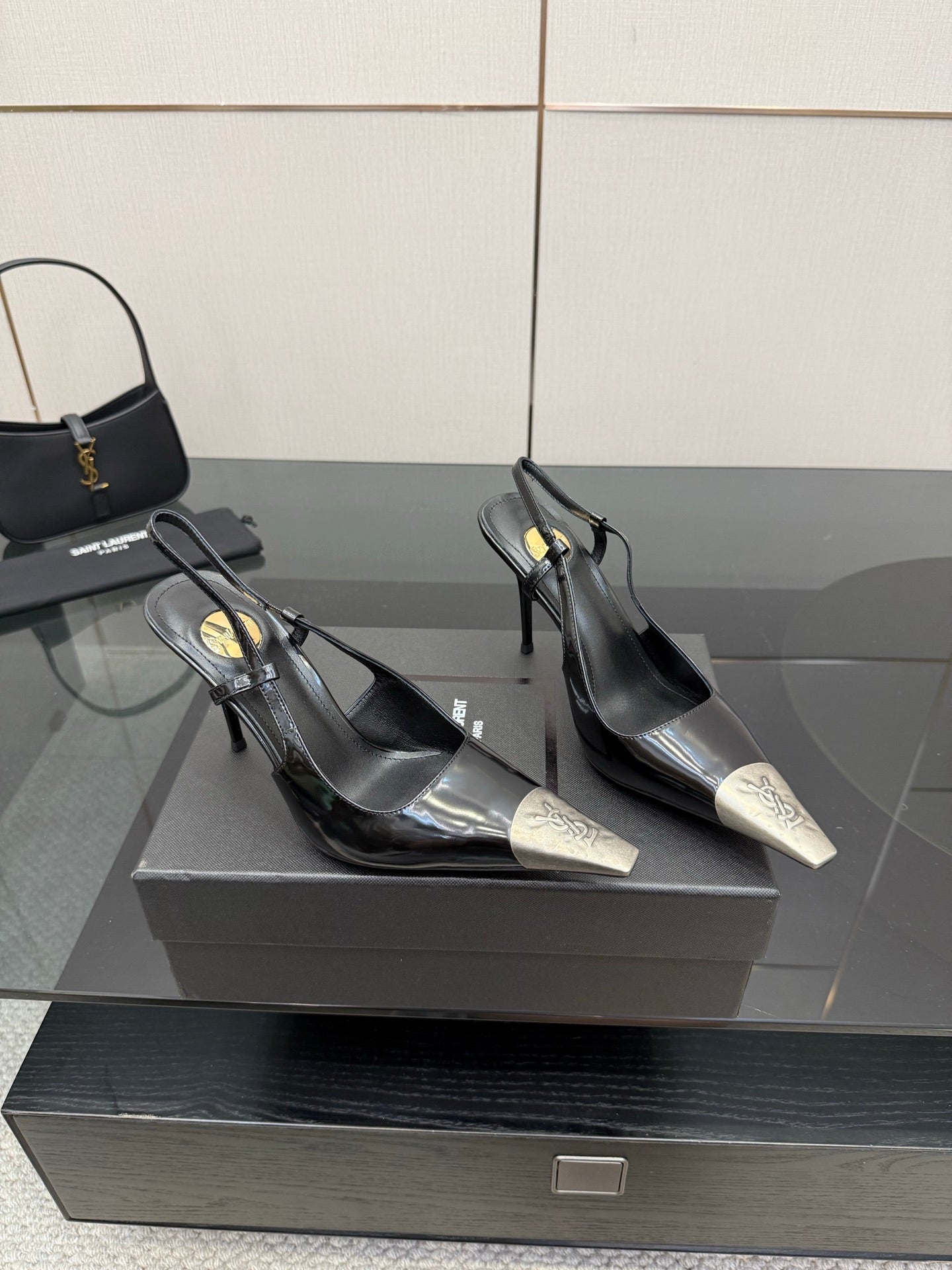 Women's YSL black slingback pumps with gold-logo tips and stiletto heels