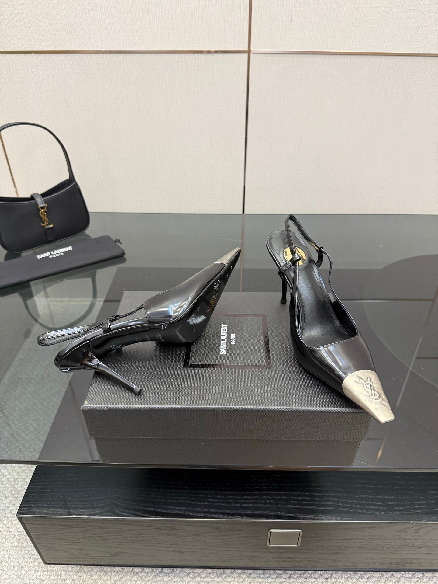 Women's YSL black pumps with stiletto heels and silver pointed toe caps, on box