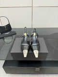 Women's YSL black pointed-toe mules with high stiletto heels, on display