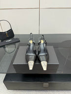Women's YSL black pointed-toe mules with high stiletto heels, on display