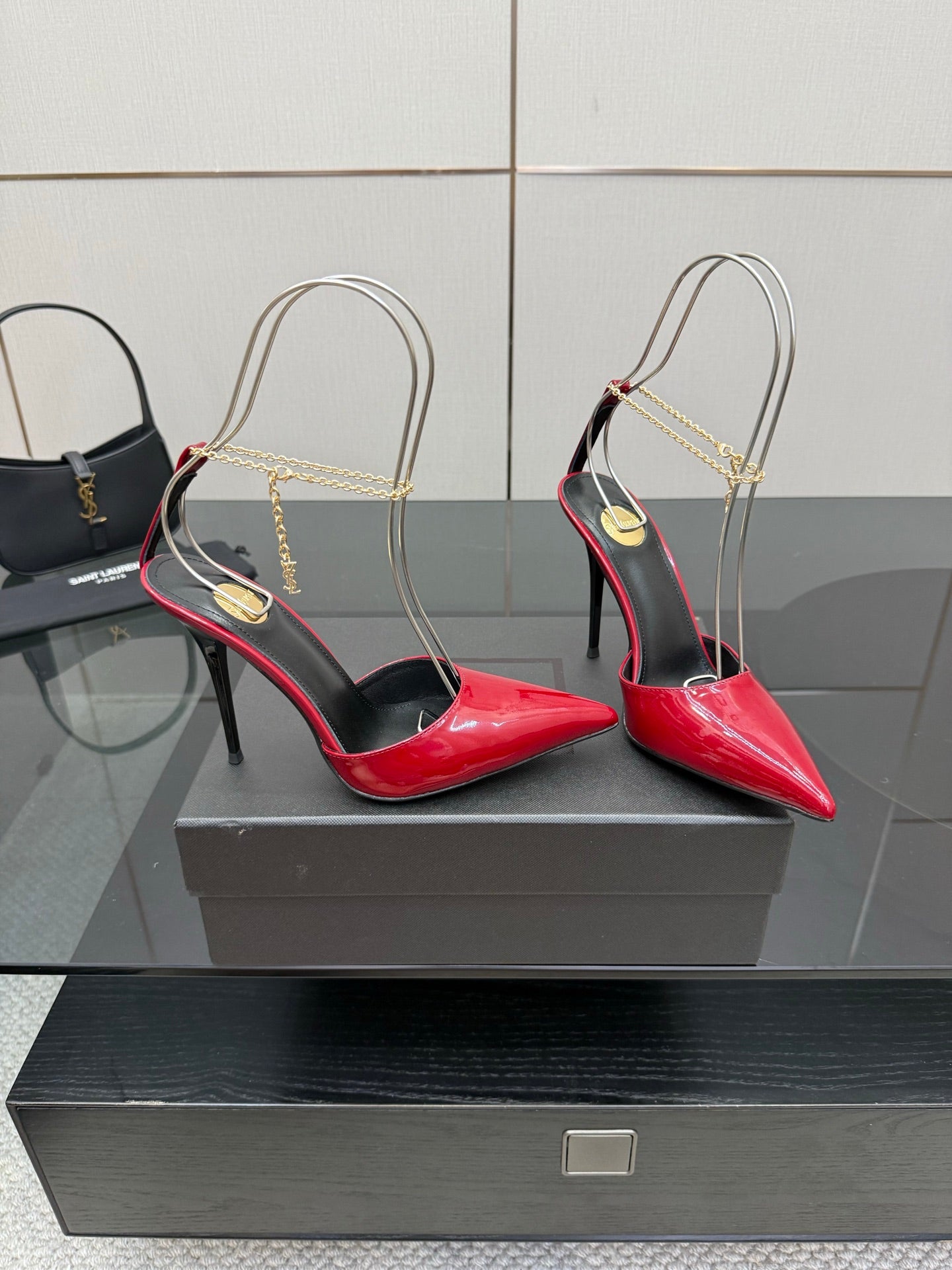 Women’s red patent pointed-toe stiletto heels with gold chain slingbacks and black trim