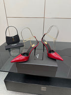 Women’s red patent pointed-toe stiletto heels with gold chain strap and black trim