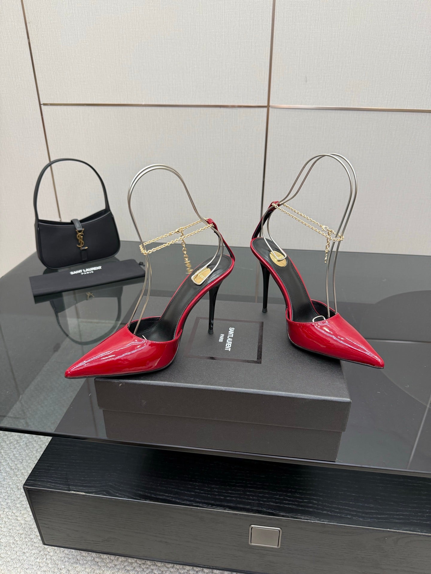 Women’s red patent pointed-toe stiletto heels with gold chain strap and black trim