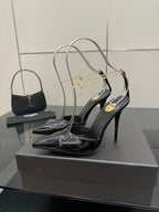 Women’s black patent leather high-heel slingback pumps with gold chain detailing