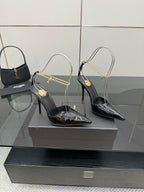 Women’s black patent leather pointed-toe high heels with gold chain strap