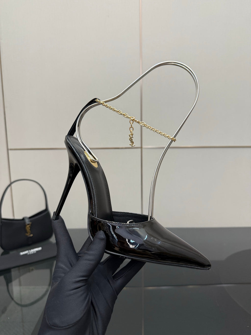 Women’s black patent leather stiletto pump on gold chain slingback strap