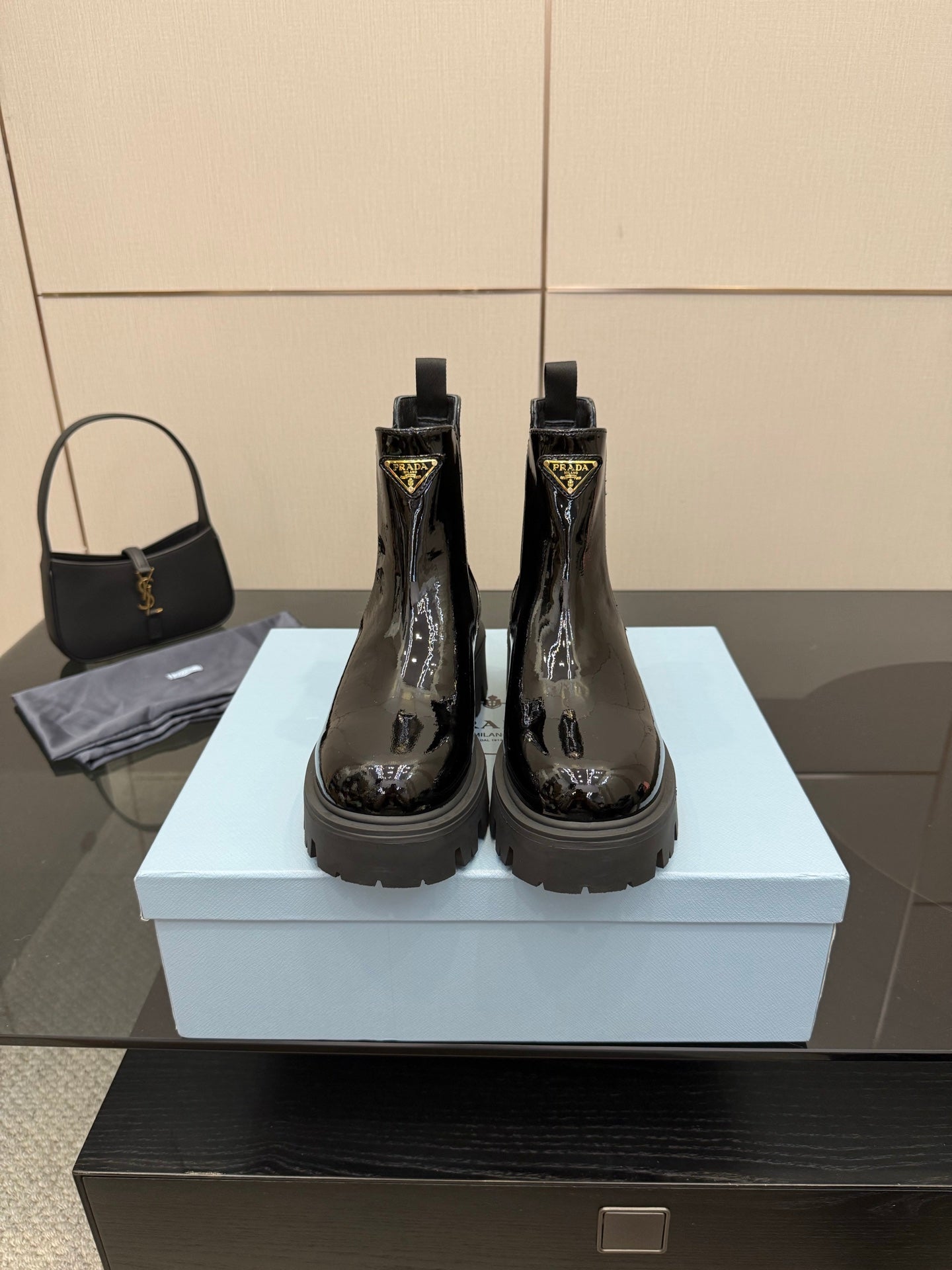Black patent Chelsea boots with side Prada logo and chunky lug sole, pair on box