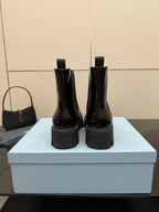 Black patent Chelsea boots rear view with pull tabs and chunky lug soles