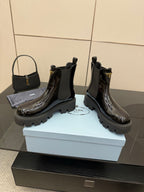 Black patent Chelsea boots, low stacked heel and lug sole with Prada logo on side