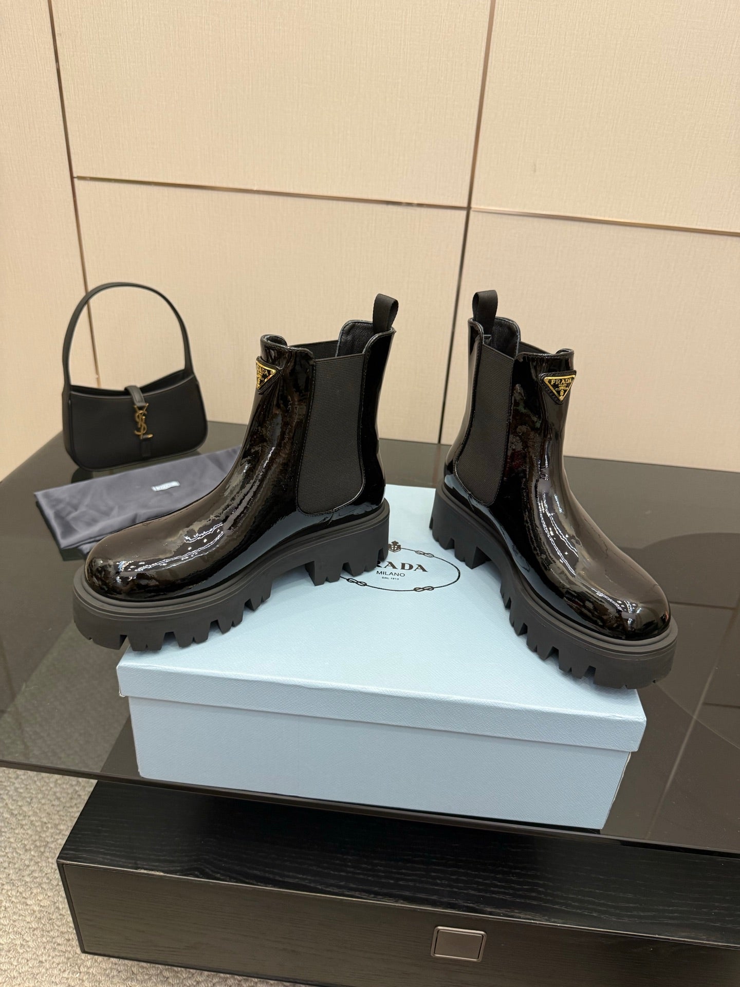 Black patent Chelsea boots, low stacked heel and lug sole with Prada logo on side