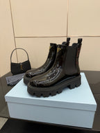 Black patent Chelsea boots with pull tabs and Prada logo badge, chunky tread sole