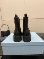 Prada black Chelsea boots with branded heel tab and thick rubber lug sole