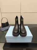 Prada black leather ankle boots with logo patch and chunky lug sole, Chelsea style