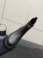 Prada black Chelsea ankle boot with gold logo patch and side pull strap