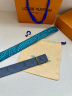 Louis Vuitton belt with turquoise dotted strap and dark monogram keeper, flat lay