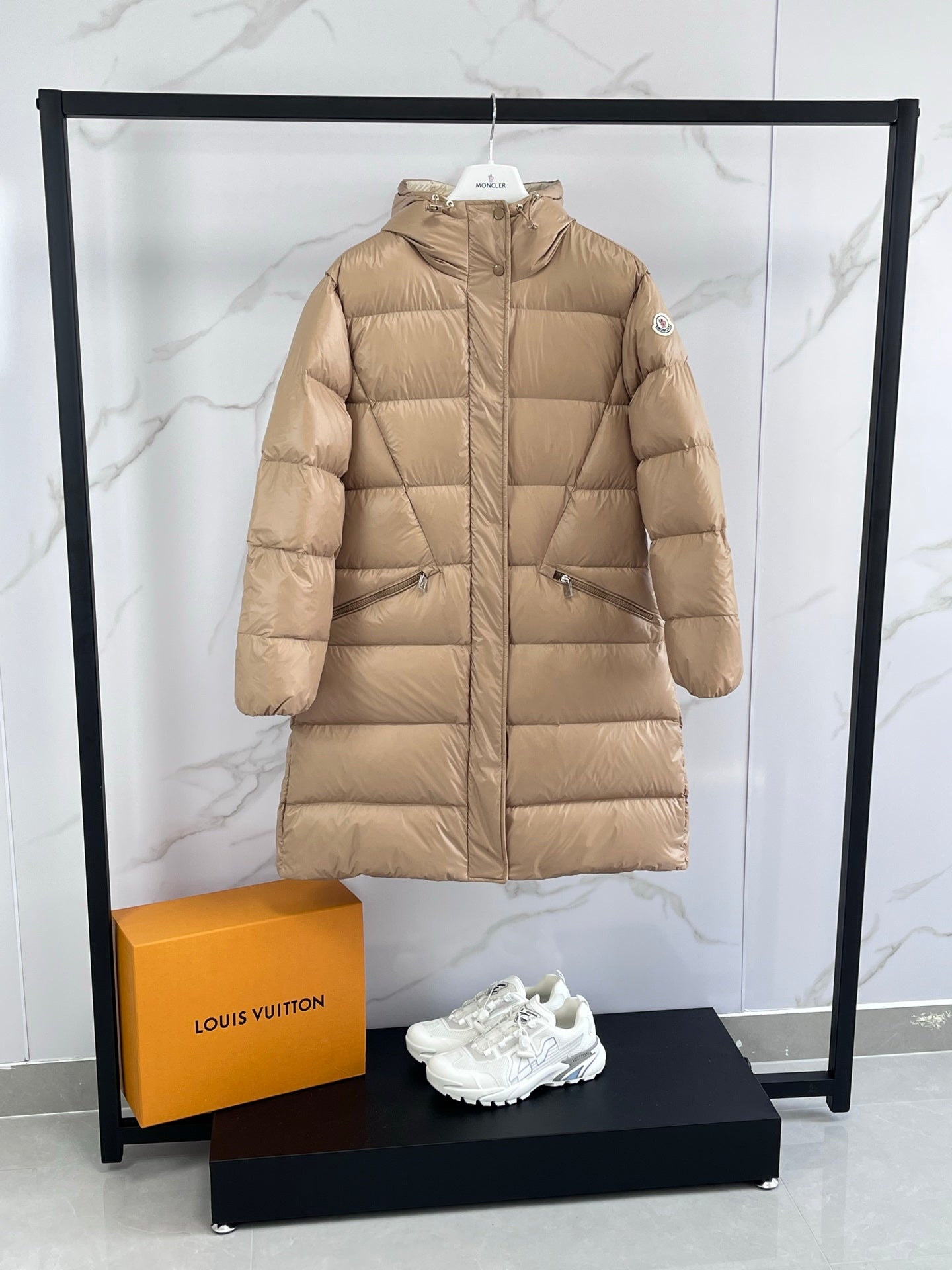 Tan long puffer coat with hood, front zip, and side pockets