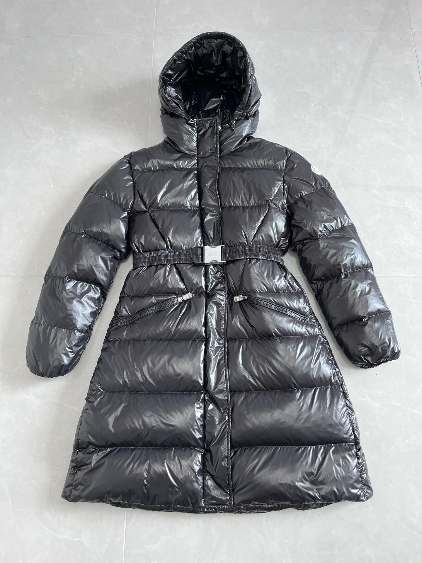 Long hooded puffer jacket with zip front and quilted panels, dark gray exterior