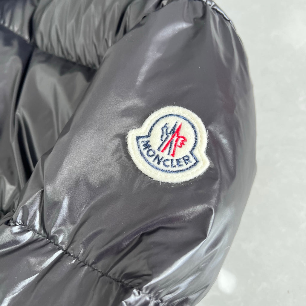 Moncler logo patch on dark gray puffer jacket sleeve
