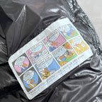 Printed fabric patch with comic-style graphics on dark gray puffer jacket lining