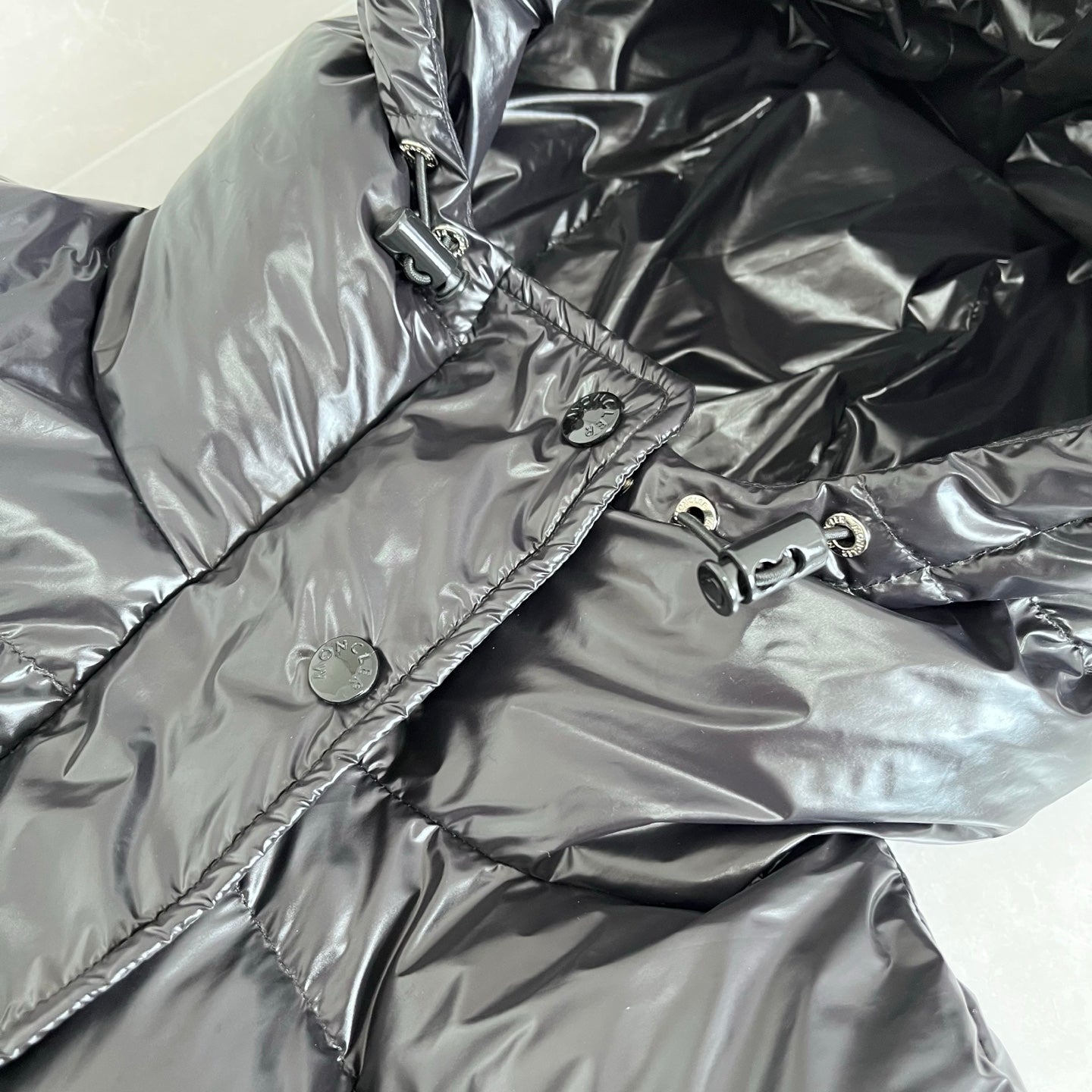 Dark gray puffer jacket hood and front placket with snap details