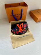 Designer belt on pouch: navy strap with red circles and orange LV logo buckle