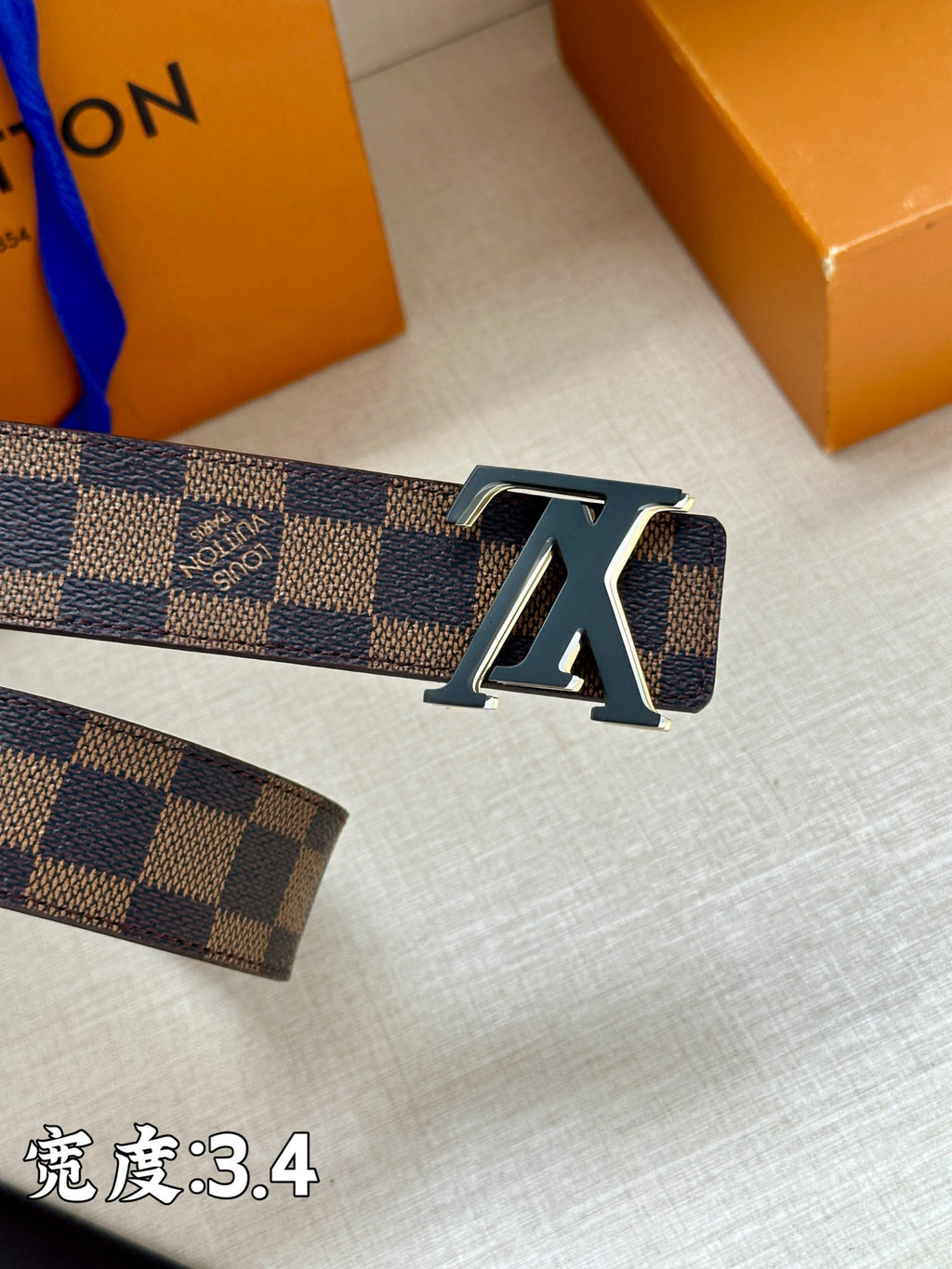 Checkered leather belt front with large LV buckle emblem