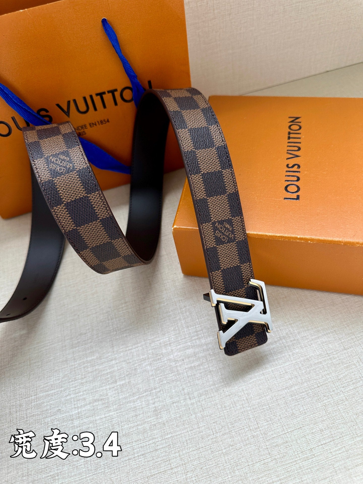 Checkered leather belt with LV buckle near end strap and metal keeper