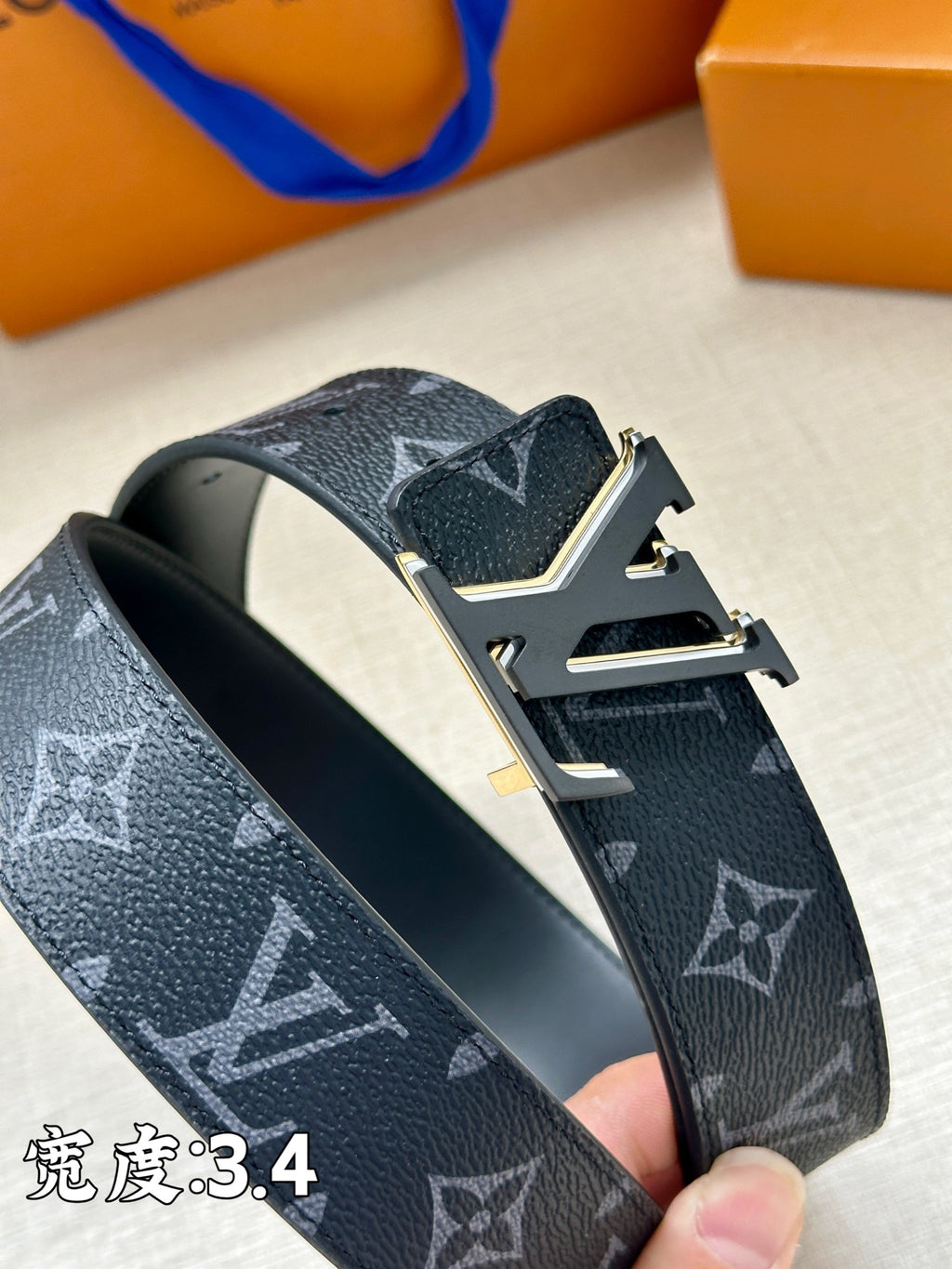 Louis Vuitton dark blue monogram belt close-up with gold-tone buckle and leather texture