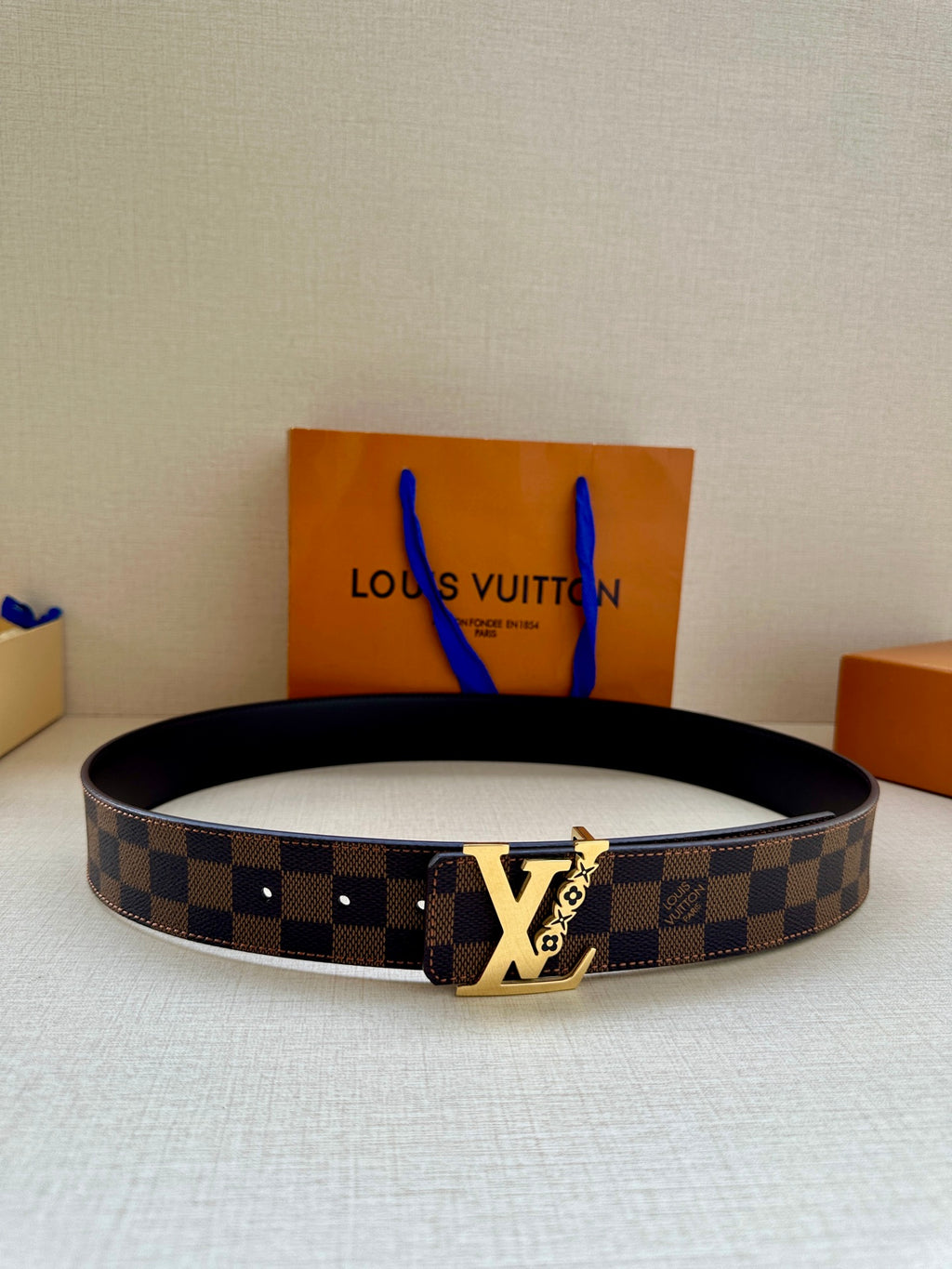Louis Vuitton belt with dark check canvas and gold-tone LV buckle, black leather strap