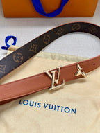 Louis Vuitton belt close-up with monogram strap, tan center, and gold V buckle