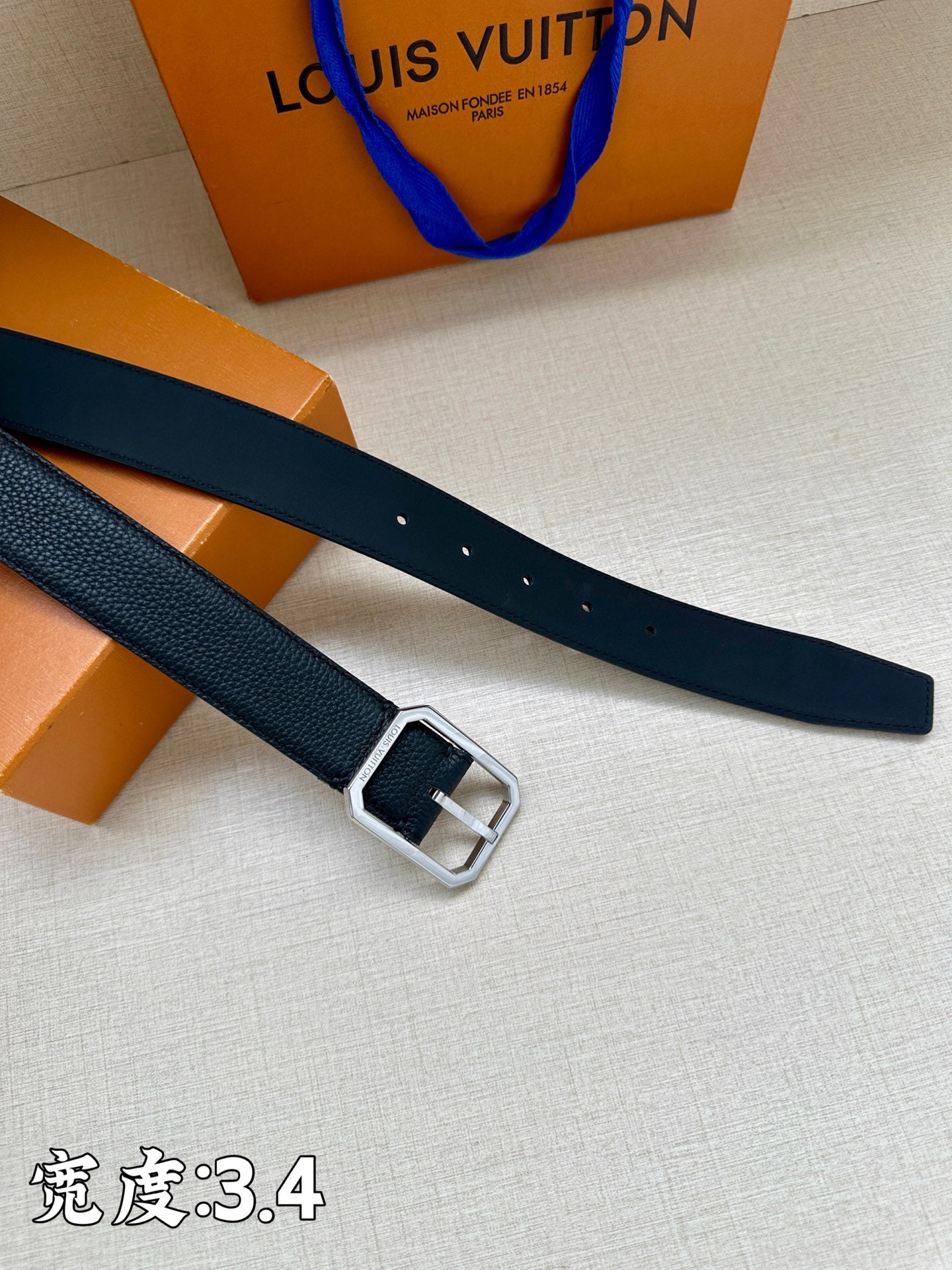 Louis Vuitton belt strap with dark blue leather and metal buckle, side view