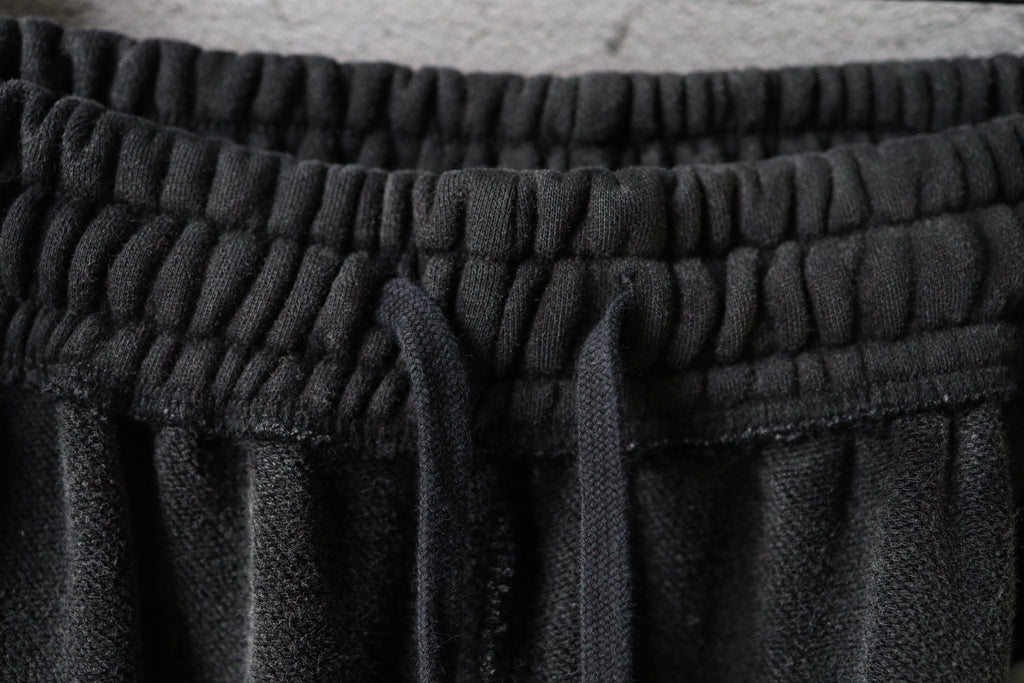Black elastic waistband with gathered fabric and drawstring