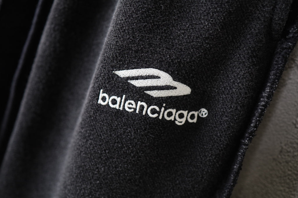 Balenciaga logo print on black pants fabric, close-up.