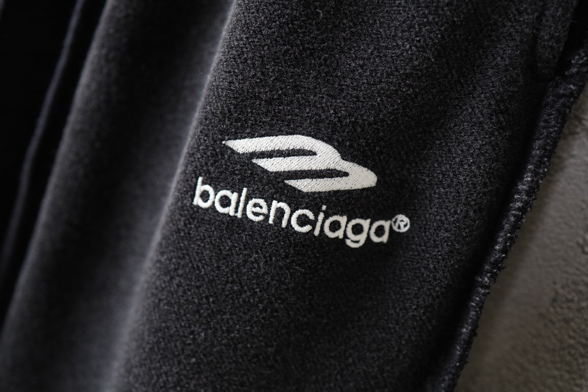 Balenciaga logo print on black pants fabric, close-up.