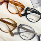 MiuMiu eyeglasses close-up with brown, black, and clear full-rim frames
